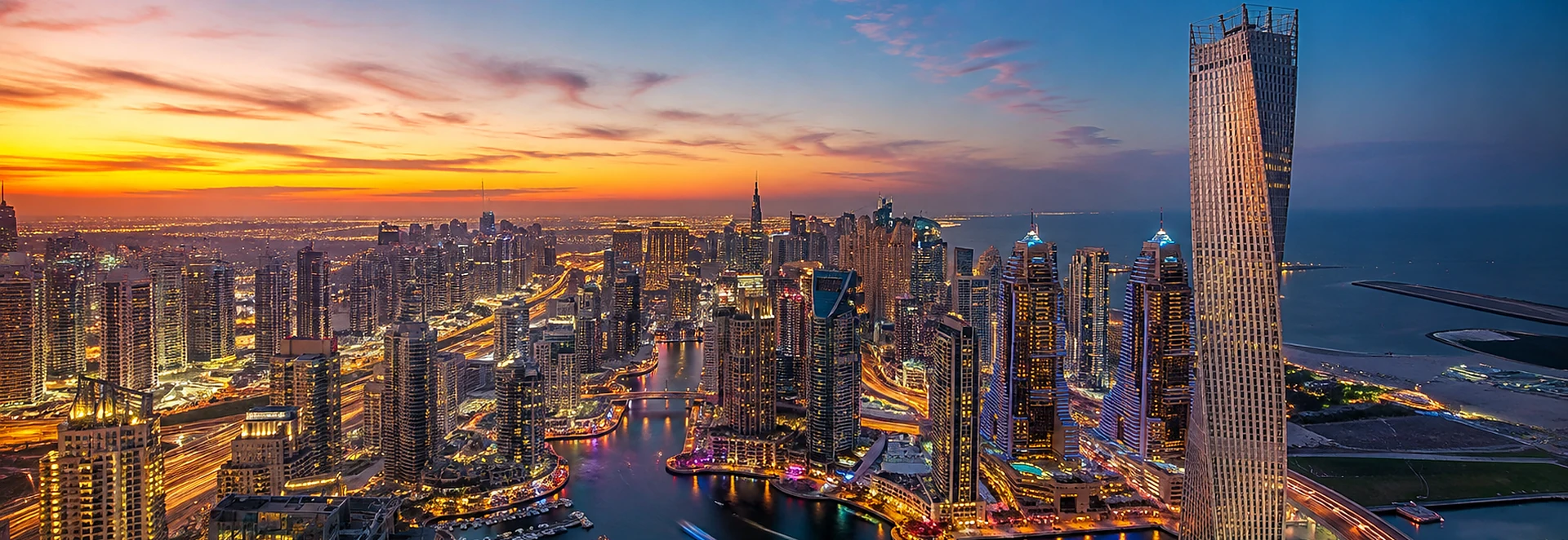 Vista panorâmica sobre a marina do Dubai ao anoitecer, com arranha-céus iluminados