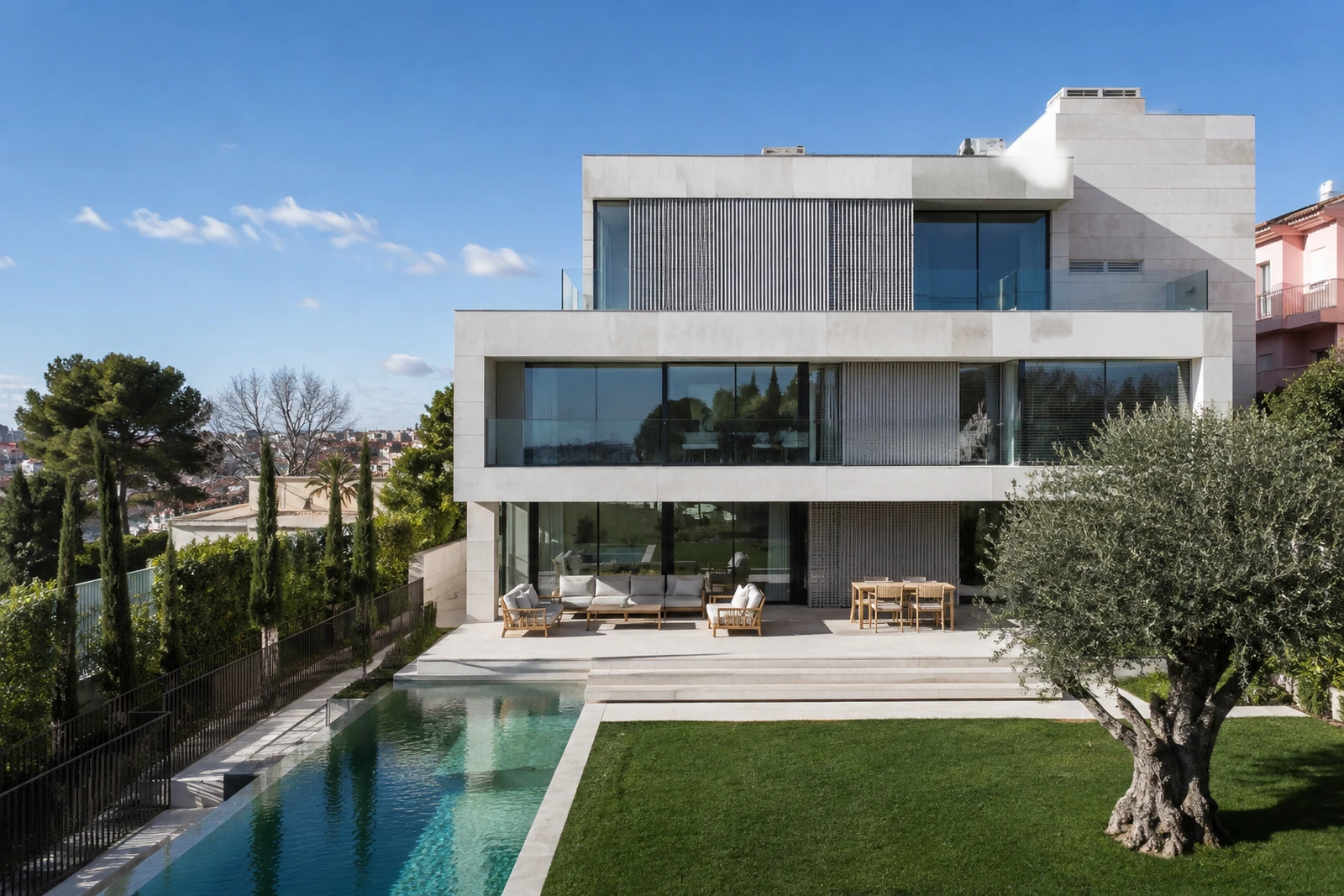 Vivenda contemporânea revestida a pedra, com amplos vãos envidraçados e piscina